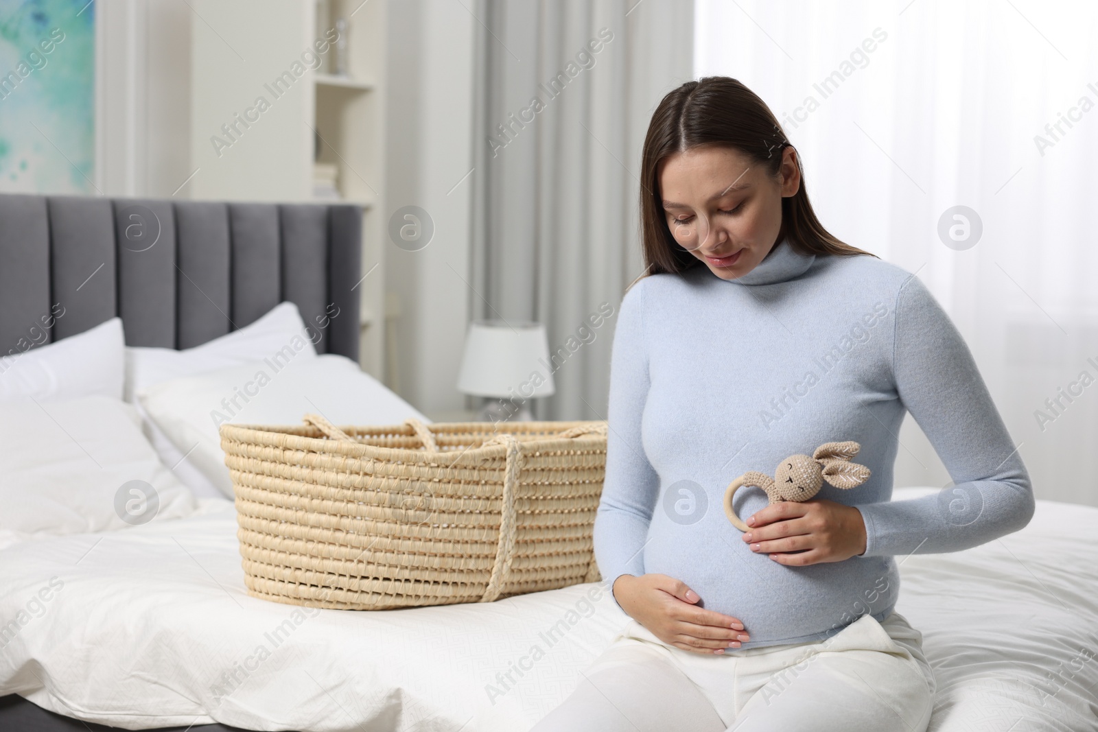 Photo of Beautiful pregnant woman with bunny toy in bedroom