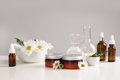 Skin care products, ingredients and laboratory glassware on table. Dermatology research