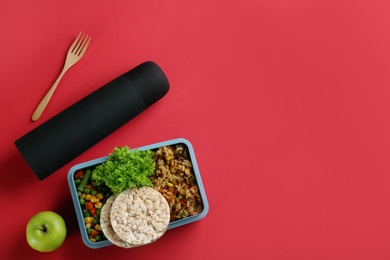 Photo of Thermos and lunch box with food on red background, flat lay. Space for text