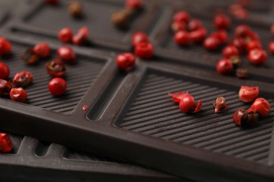 Photo of Delicious chocolate bar with red peppercorns as background, closeup