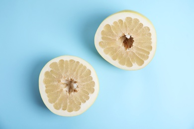 Photo of Fresh cut pomelo fruit on light blue background, flat lay