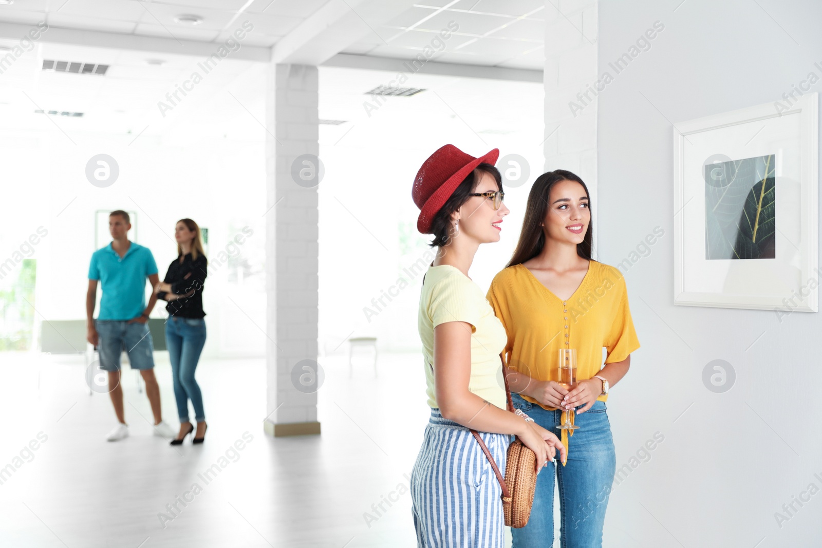 Photo of Young women at exhibition in art gallery