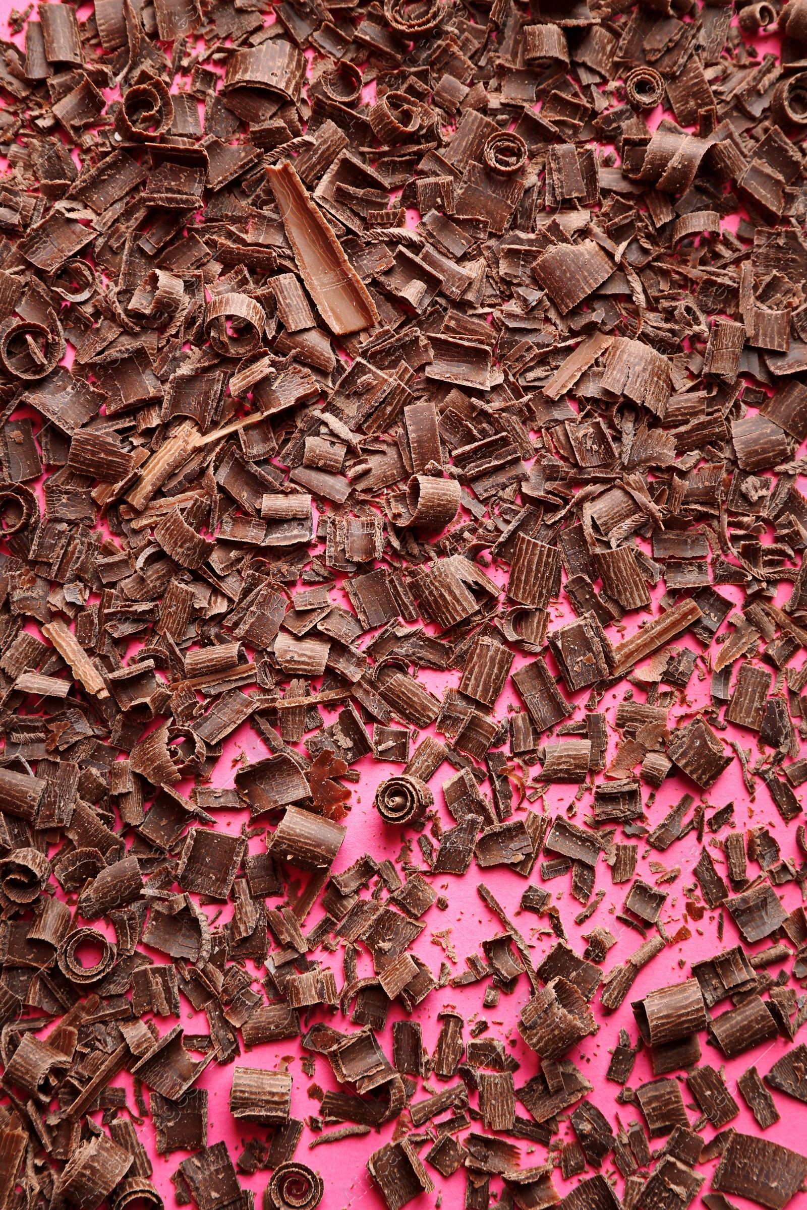 Photo of Chocolate curls on color background, top view