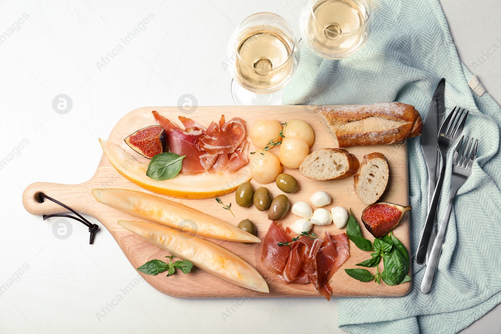 Photo of Flat lay composition with melon and prosciutto appetizer on table