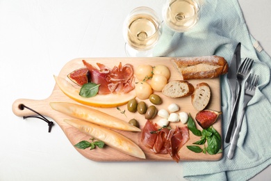 Flat lay composition with melon and prosciutto appetizer on table