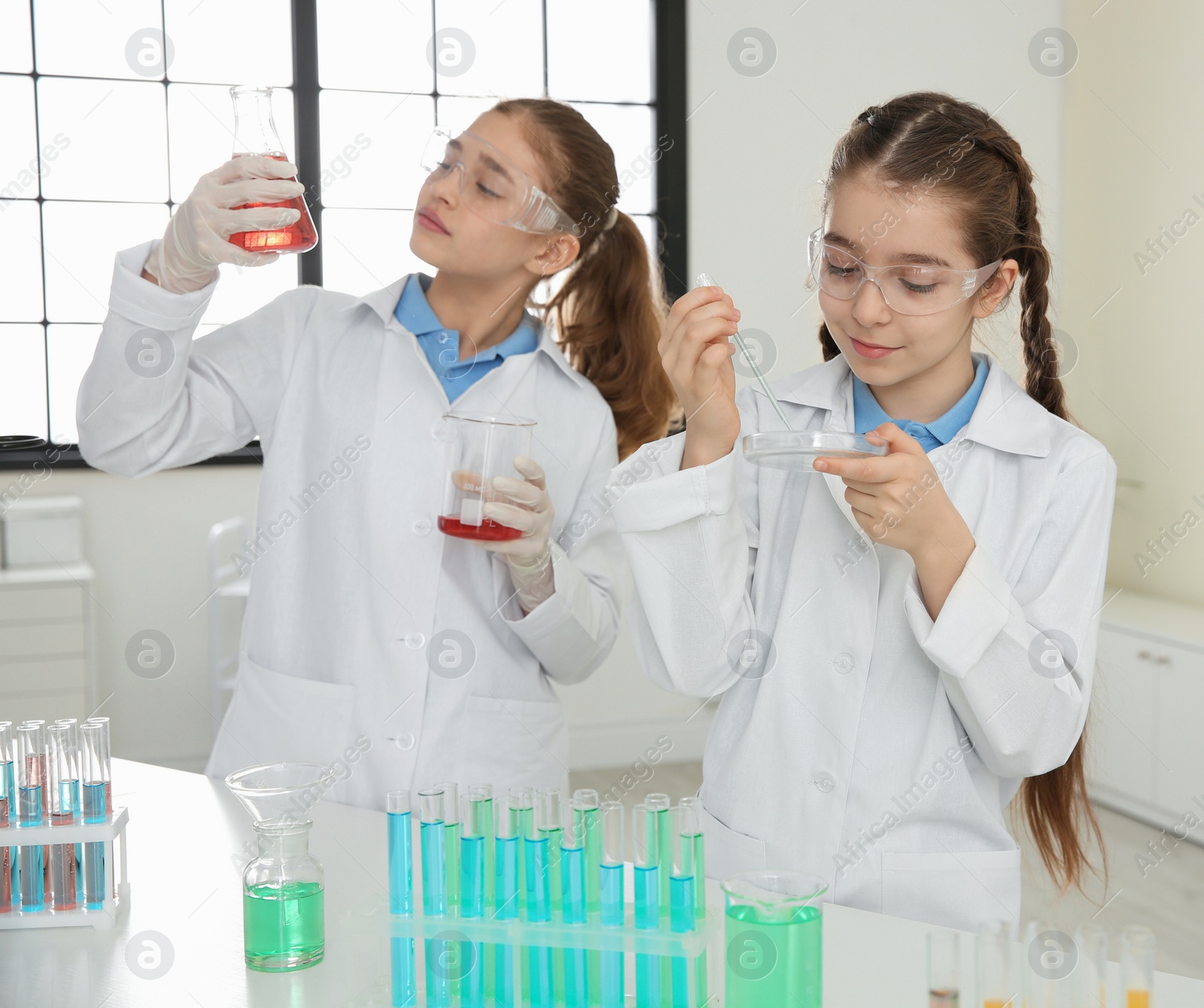 Photo of Smart pupils making experiment in chemistry class