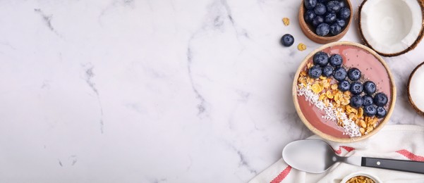 Image of Smoothie bowl with muesli, shredded coconut and blueberries on white marble table, flat lay. Banner design with space for text