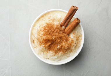 Delicious rice pudding with cinnamon on light table, top view