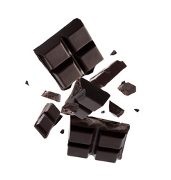 Pieces of dark chocolate falling on white background