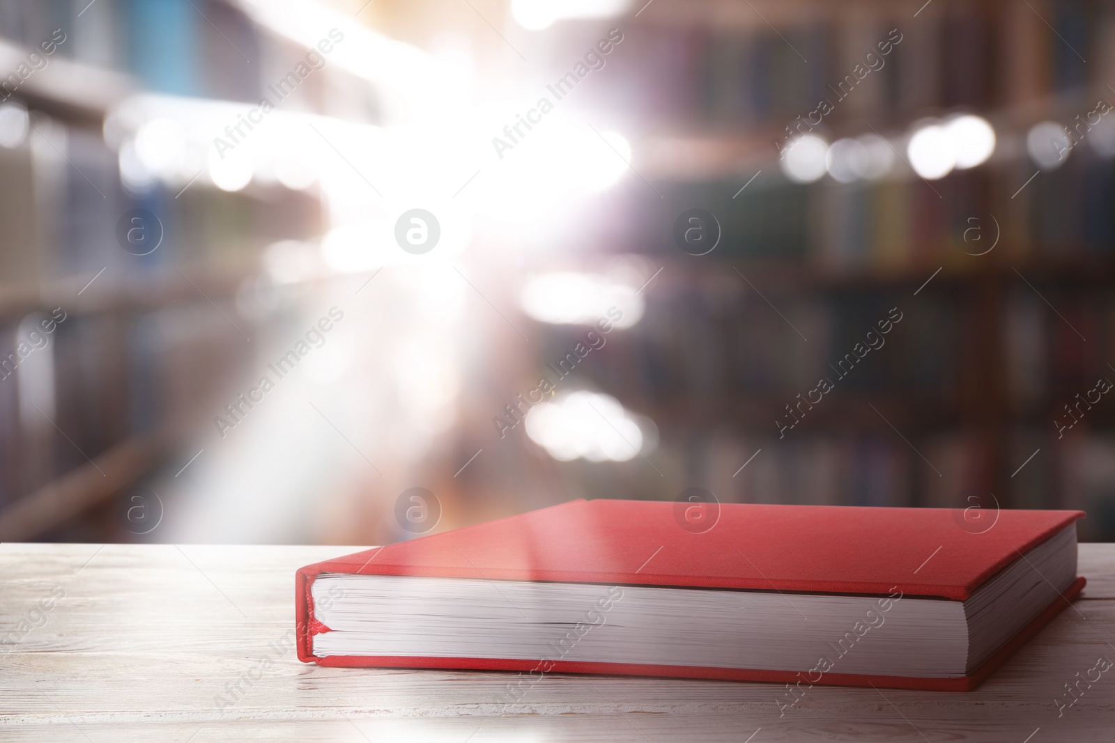 Image of Book with red cover on wooden table in library