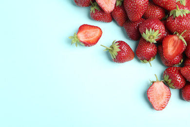 Photo of Tasty ripe strawberries on light blue background, flat lay. Space for text