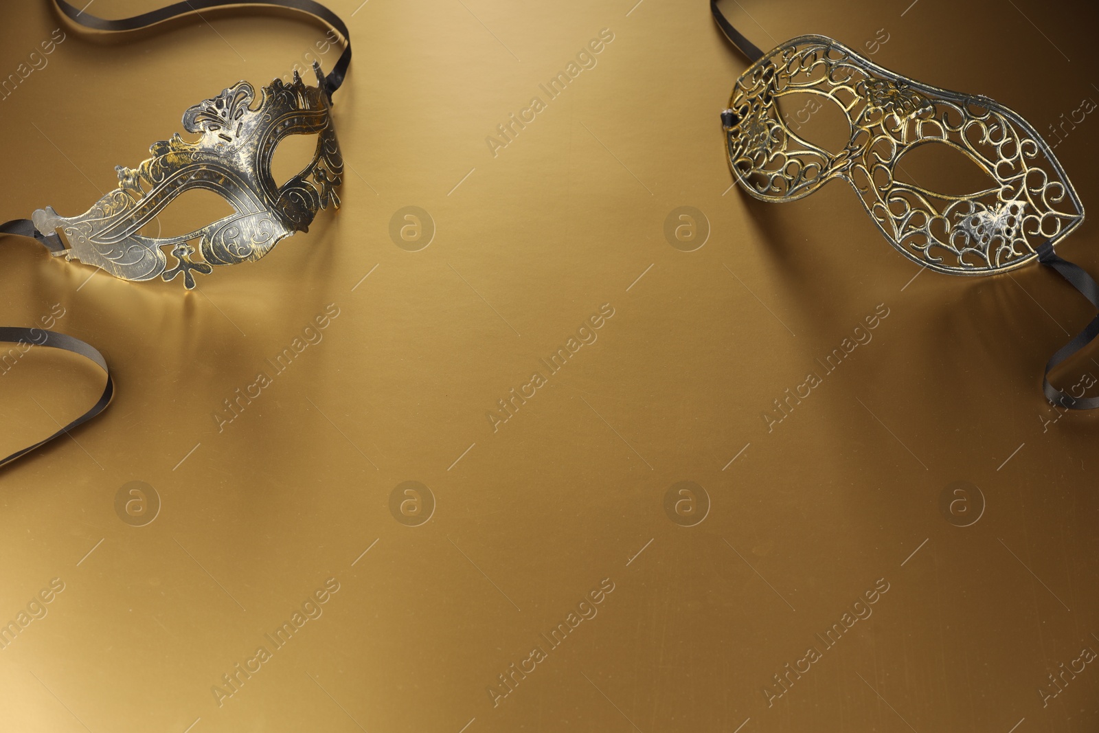 Photo of Elegant face masks on beige background, space for text. Theatrical performance