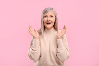 Photo of Portrait of emotional middle aged woman on pink background