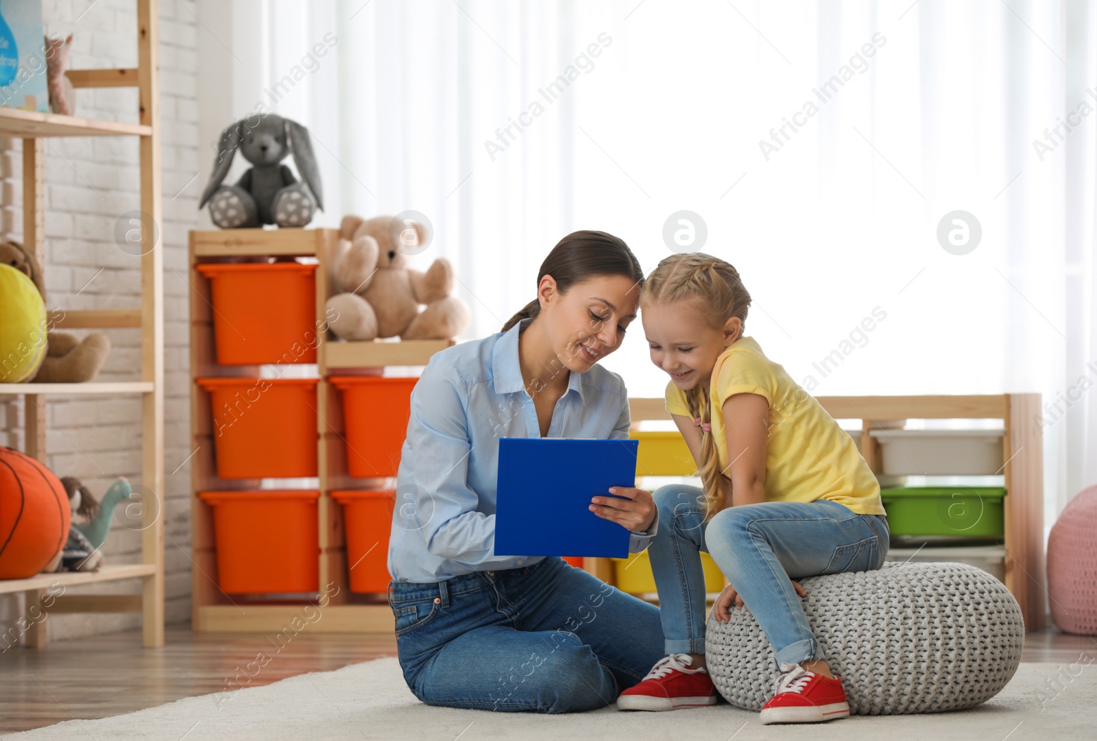 Photo of Child psychotherapist working with little girl in office