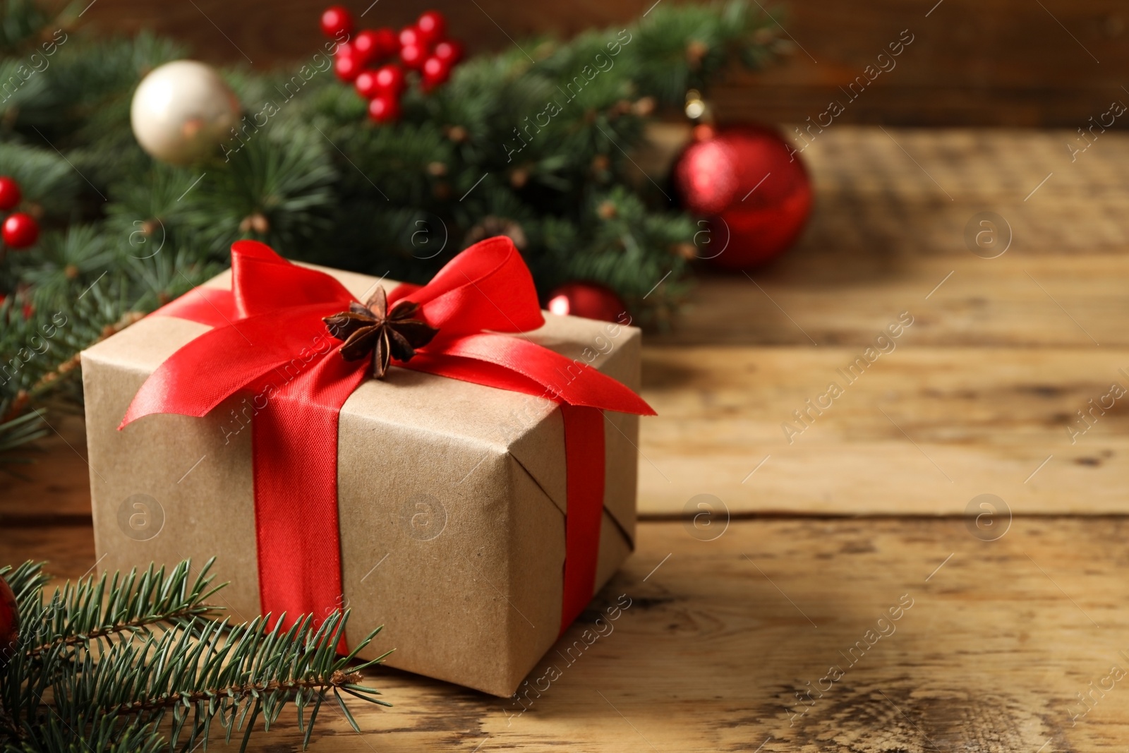 Photo of Christmas gift box on wooden table, closeup. Space for text