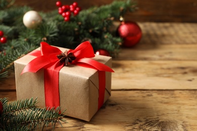 Photo of Christmas gift box on wooden table, closeup. Space for text