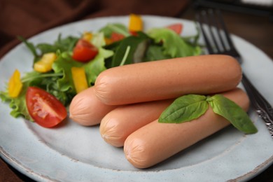 Photo of Delicious boiled sausages with salad on table, closeup