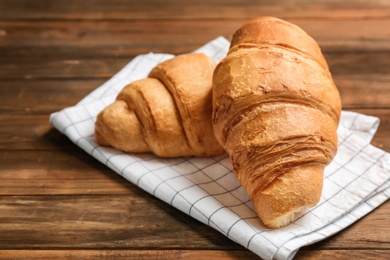 Photo of Tasty croissants on wooden background