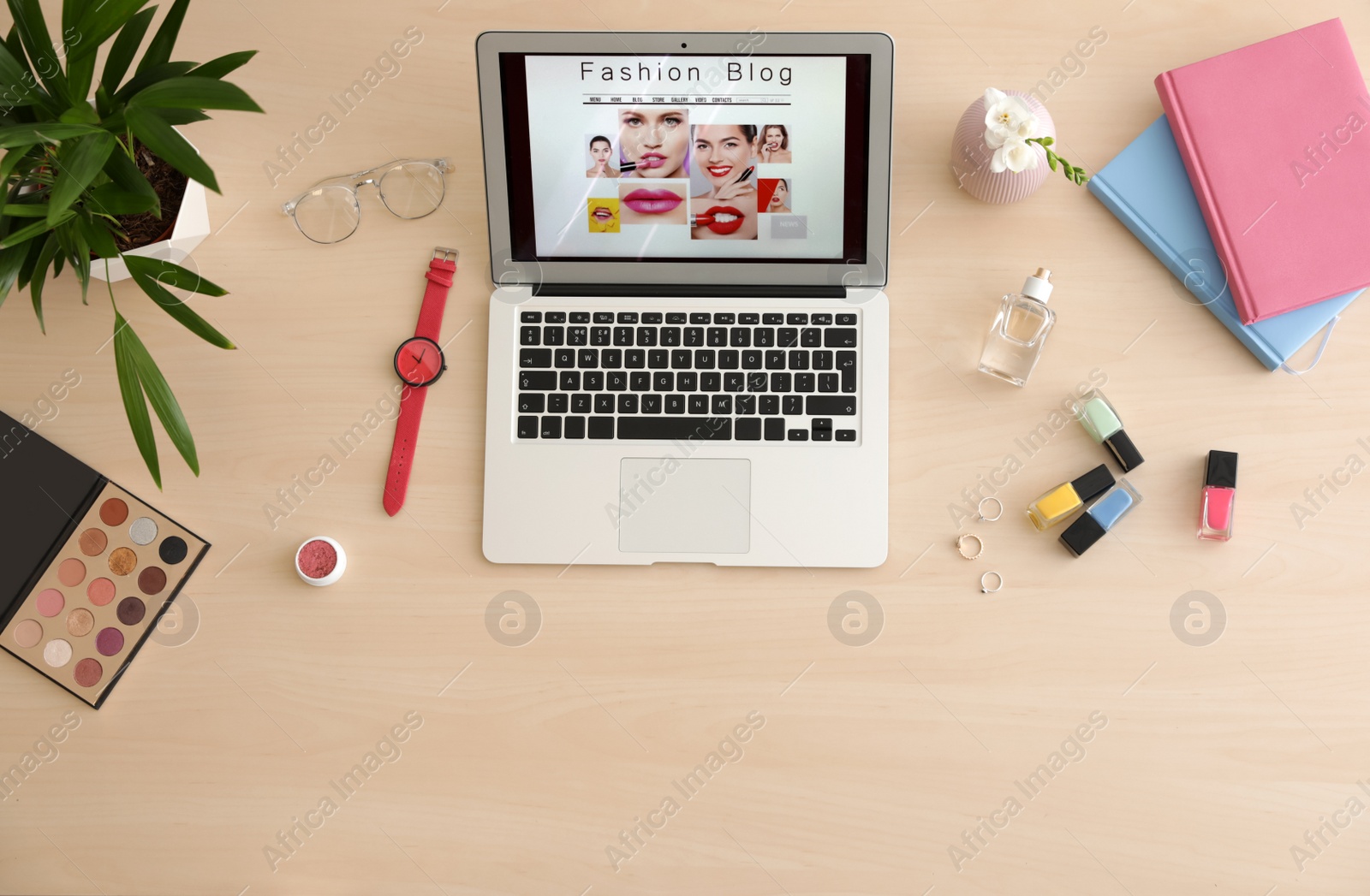 Photo of Laptop with open fashion blogger site on table, top view
