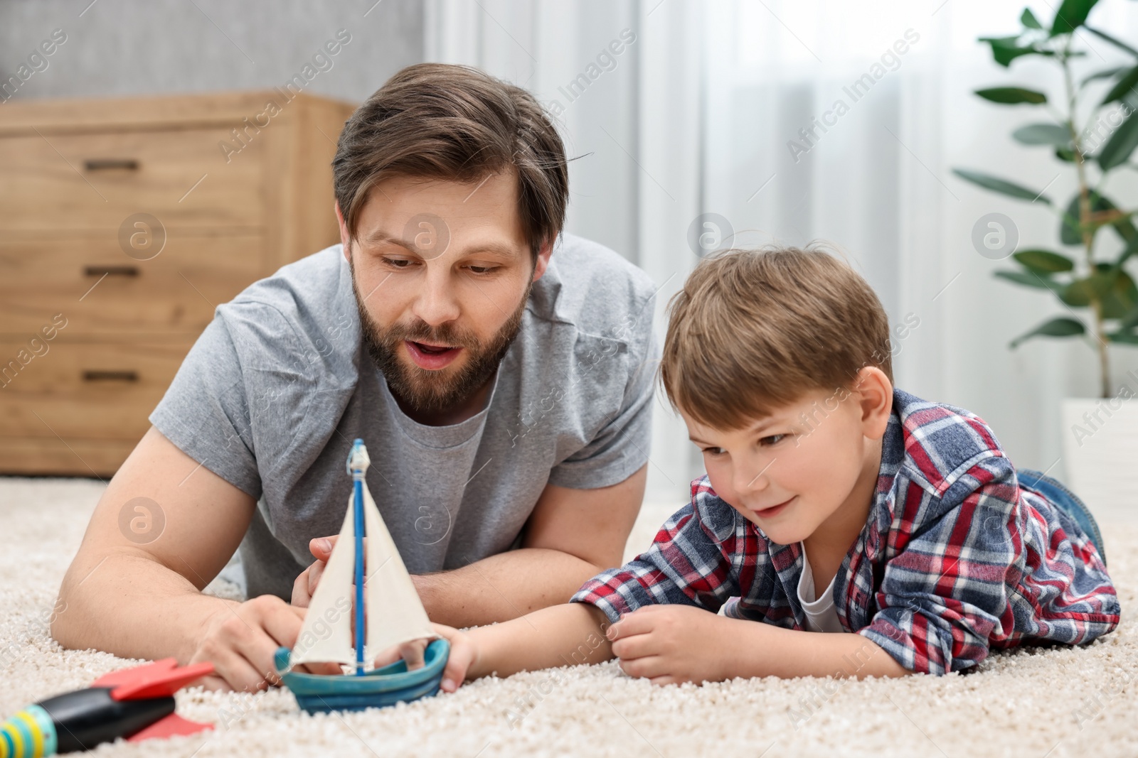 Photo of Dad and son playing toys together at home