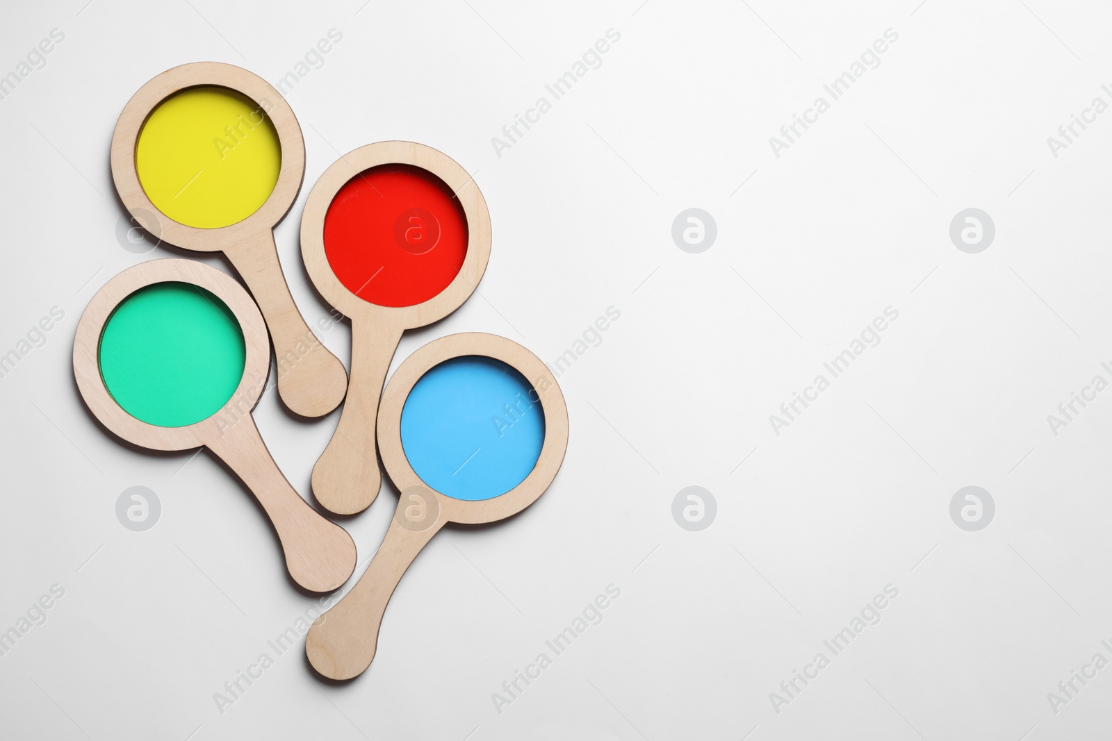 Photo of Set of colorful magnifiers on white background, top view. Montessori toy