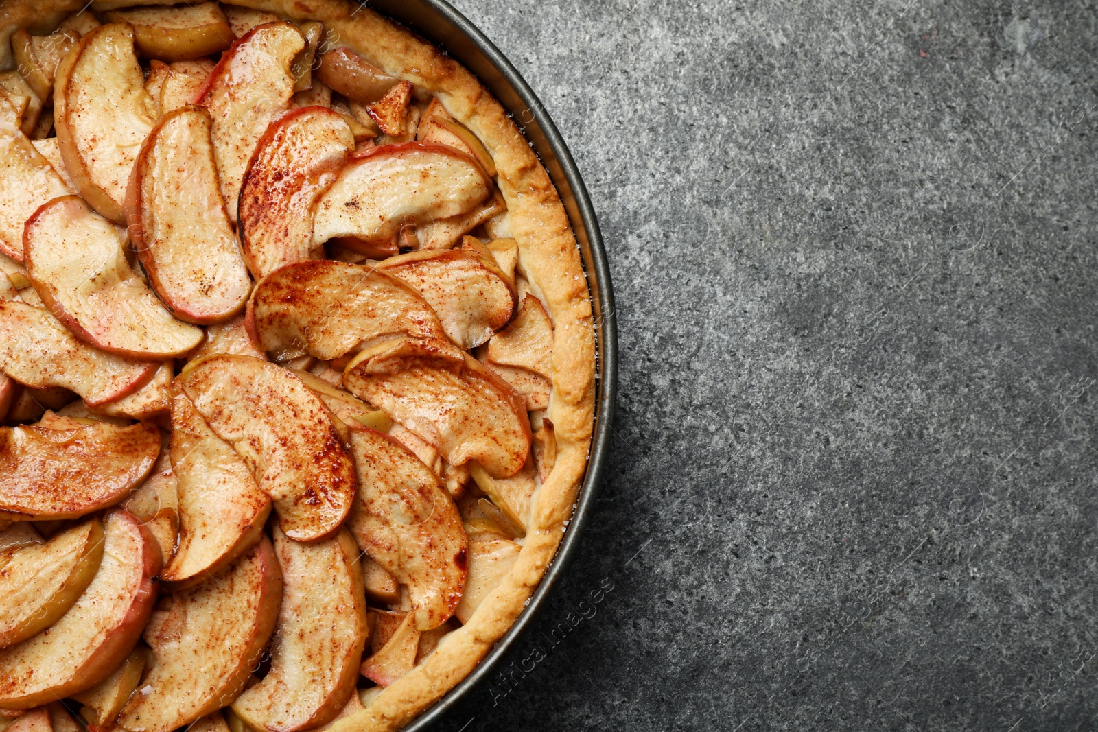 Photo of Delicious apple pie on grey table, top view. Space for text