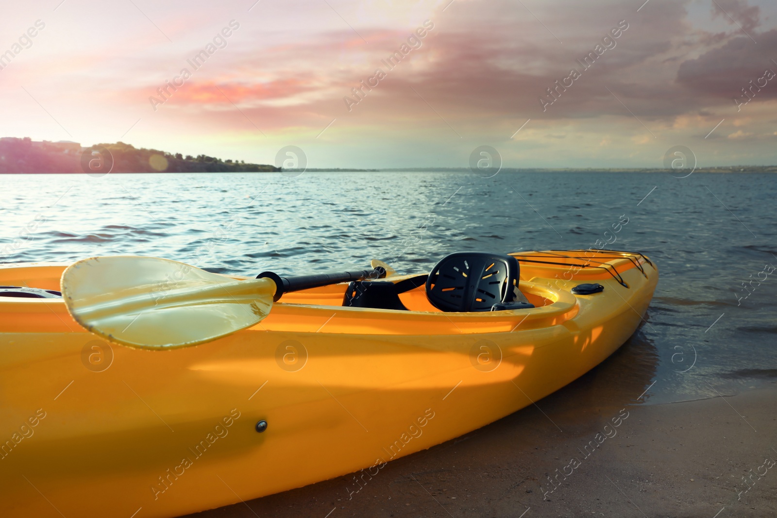 Photo of Beautiful modern yellow kayak with paddle on river