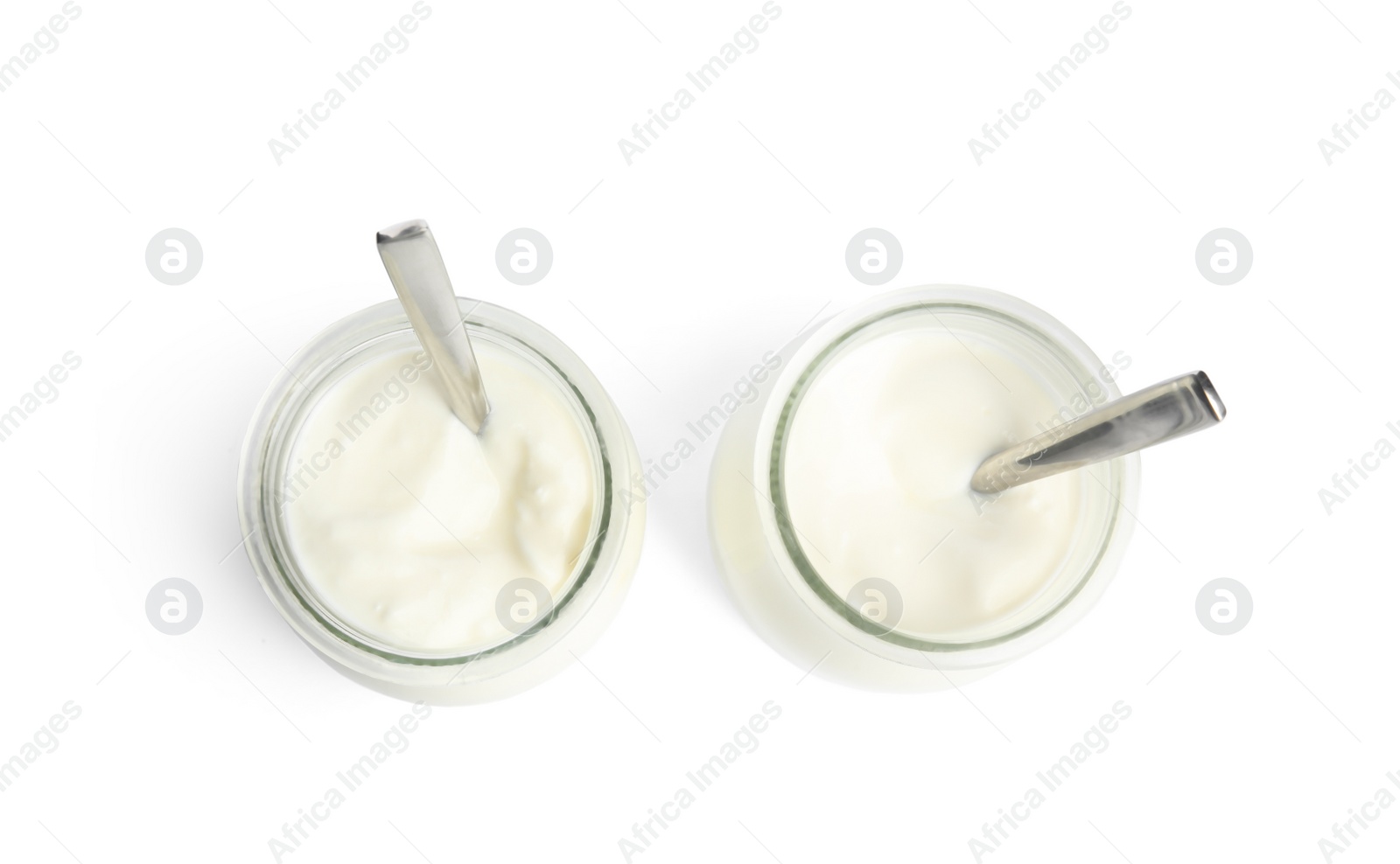 Photo of Tasty organic yogurt in glass jars with spoons isolated on white, top view