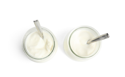 Photo of Tasty organic yogurt in glass jars with spoons isolated on white, top view