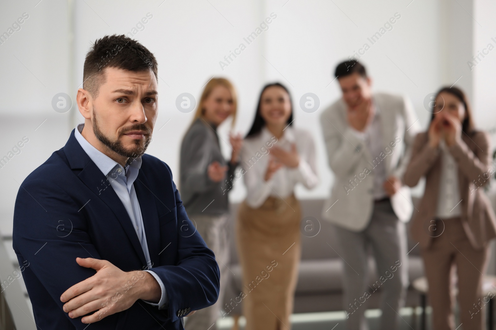 Photo of Coworkers bullying their colleague in office, space for text