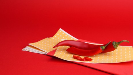 Photo of Pepper plasters and chili on red background, space for text. Alternative medicine