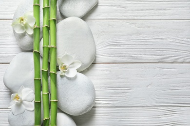 Photo of Flat lay composition with green bamboo stems on wooden background. Space for text