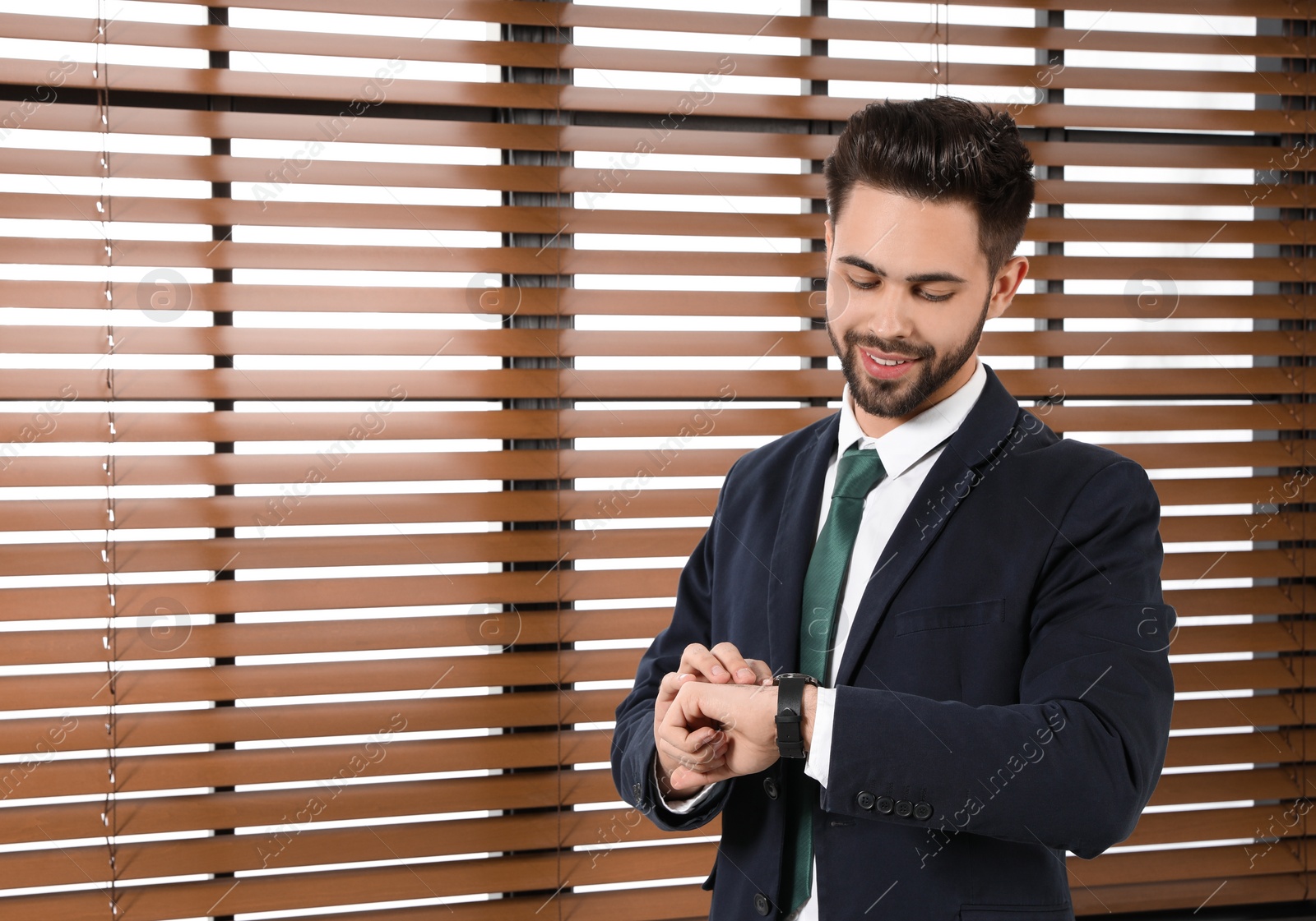 Photo of Portrait of confident businessman checking time at window indoors. Space for text