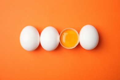 Photo of Raw chicken eggs on color background, top view