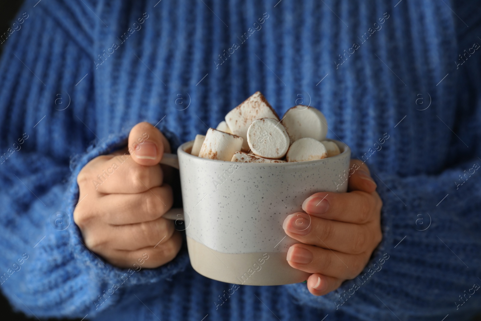 Photo of Woman holding cup of delicious hot cocoa with marshmallows, closeup. Winter drink