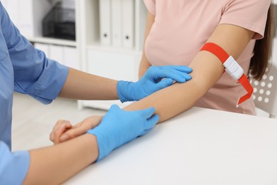 Photo of Laboratory testing. Doctor taking blood sample from patient at white table in hospital, closeup