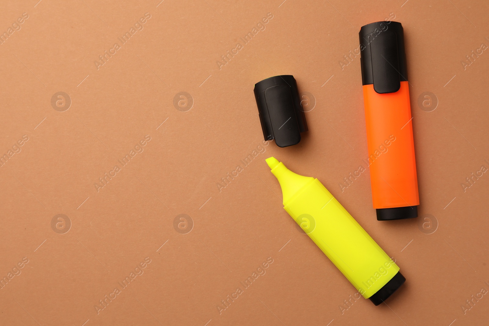 Photo of Bright color markers on pale orange background, flat lay. Space for text