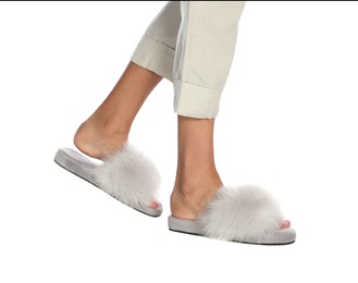 Photo of Woman in fluffy slippers on white background, closeup