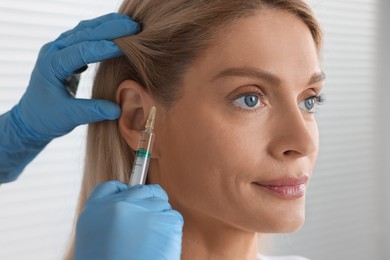 Photo of Trichologist giving injection to patient in clinic, closeup