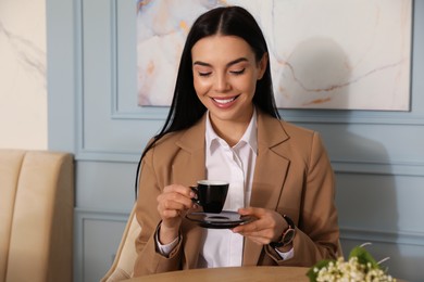Photo of Woman with cup of coffee at cafe in morning