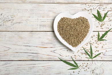 Flat lay composition with hemp seeds and space for text on wooden background