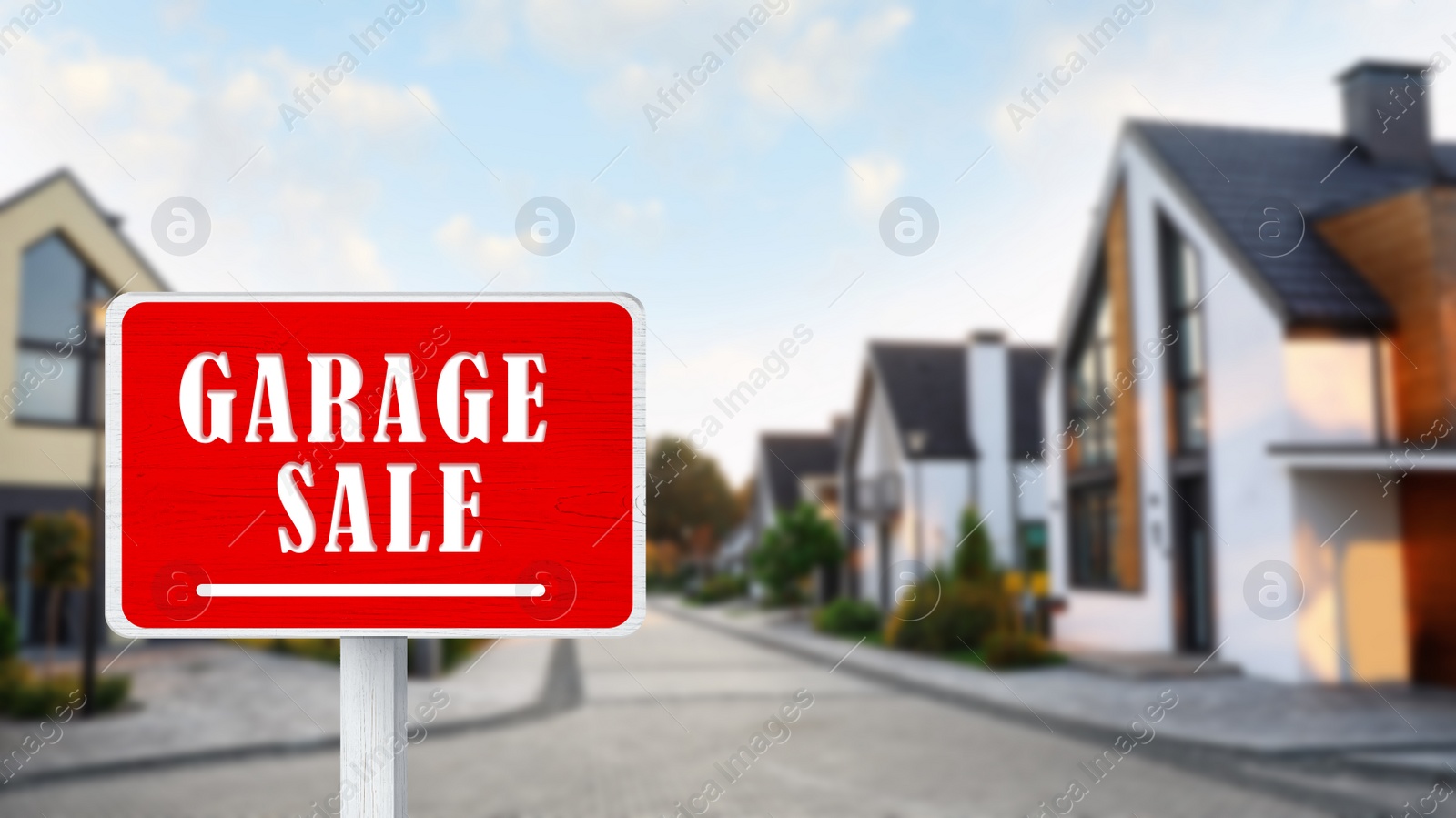 Image of Sign with phrase GARAGE SALE near houses in village