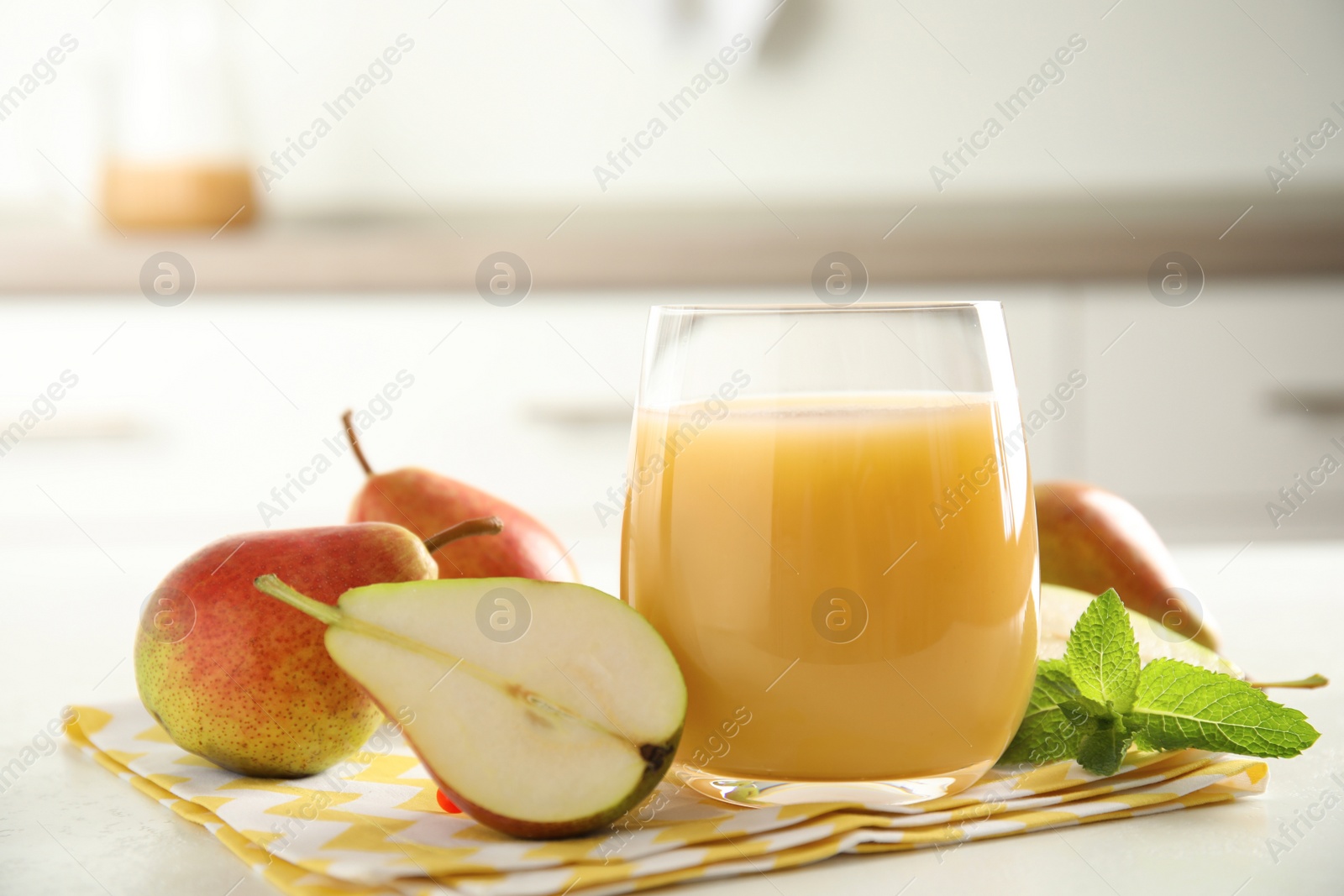 Photo of Tasty pear juice and fruits on white table, closeup