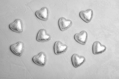 Photo of Flat lay composition with heart shaped candies on grey background