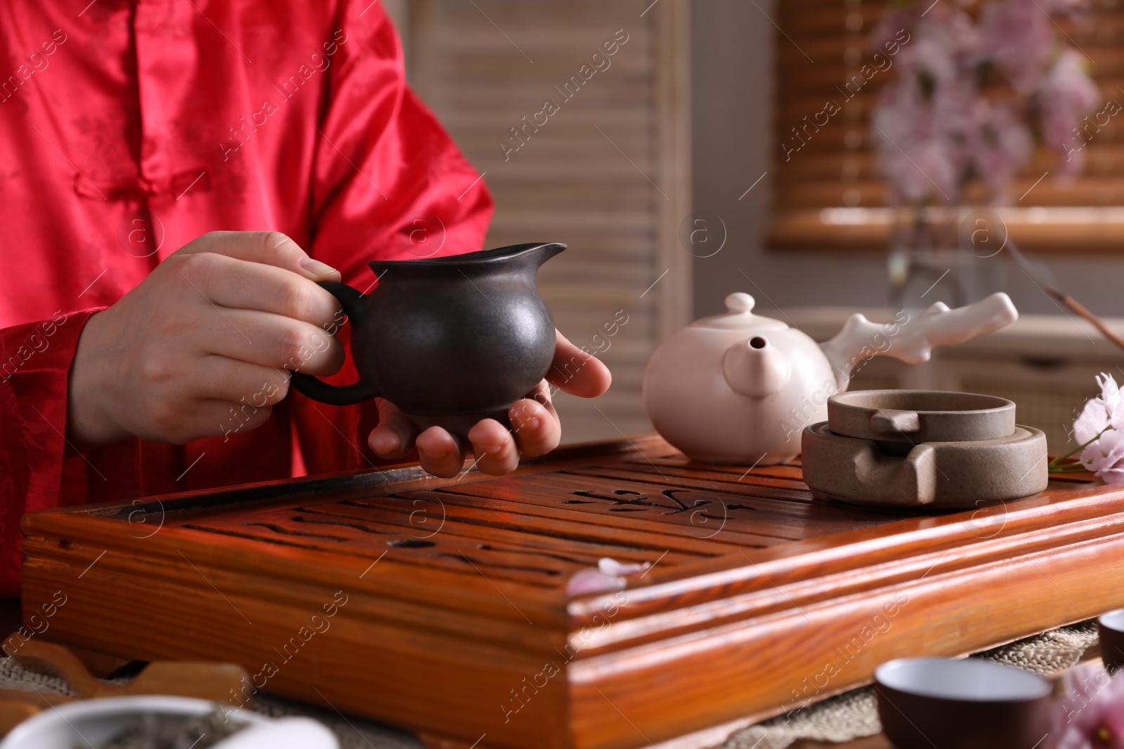 Photo of Master conducting traditional tea ceremony at table, closeup