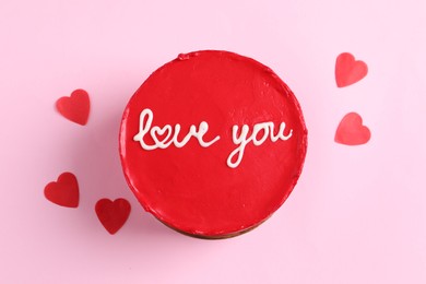 Photo of Bento cake with text Love You and paper hearts on pink table, top view. St. Valentine's day surprise