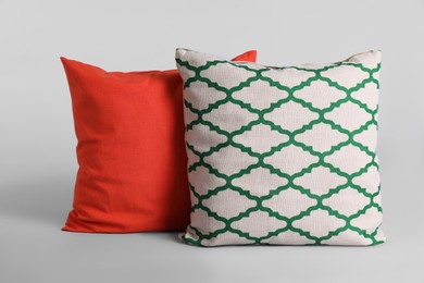 Different stylish soft pillows on grey background