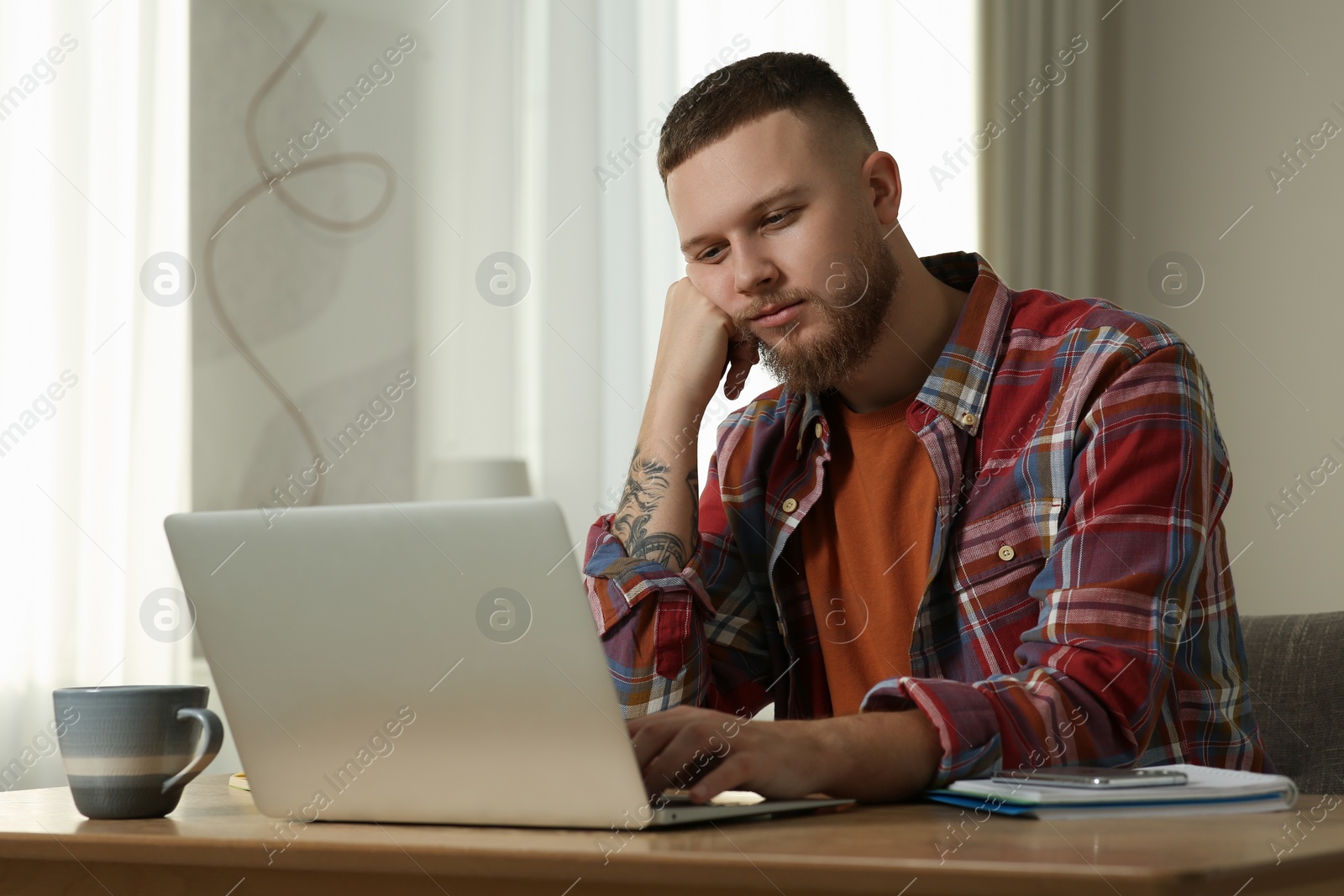 Photo of Online test. Man studying with laptop at home