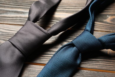 Photo of Two neckties on wooden table, closeup view