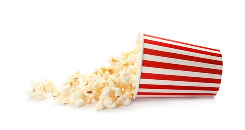 Photo of Overturned cup with delicious fresh popcorn on white background